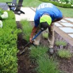 man shoveling dirt for installation pro sprinklers