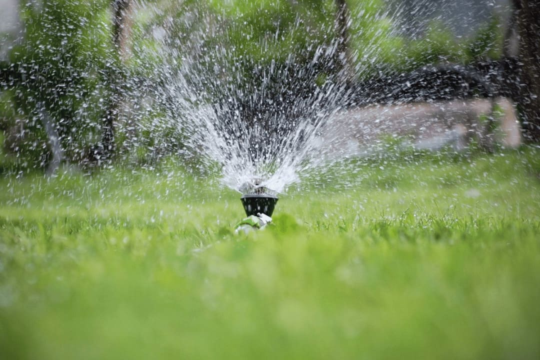 sprinkler head operating as part of a compliant irrigation system installation