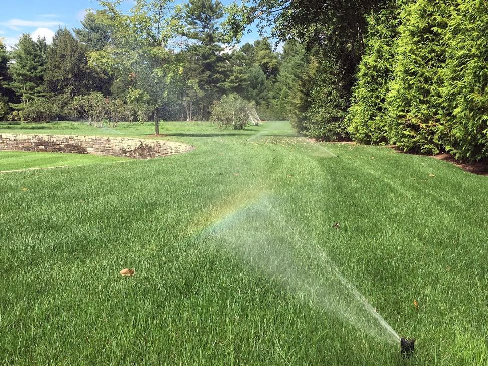Sprinkler System Irrigation Spraying Water On Landscaped Property